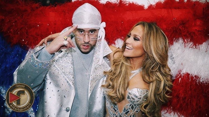 Bad Bunny and Shakira posing together in front of a Puerto Rican flag backdrop during the 2020 Super Bowl halftime show, showcasing Latin pride and cultural representation