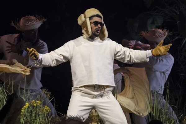 Bad Bunny in white outfit and straw hat performs with backup dancers in Puerto Rican-inspired theatrical staging at his San Juan concert residency, July 2025