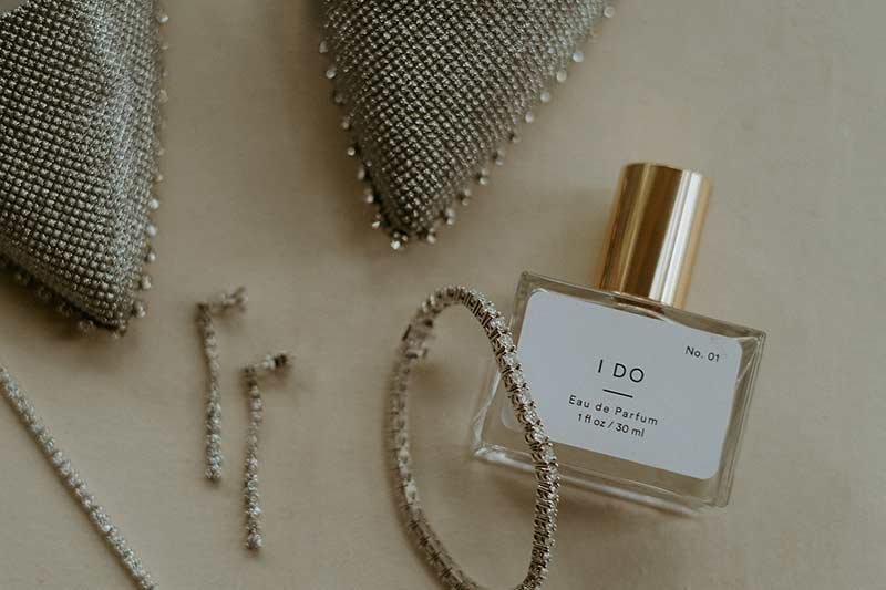 Bridal accessories including I DO perfume bottle, diamond earrings and crystal jewelry for wedding day