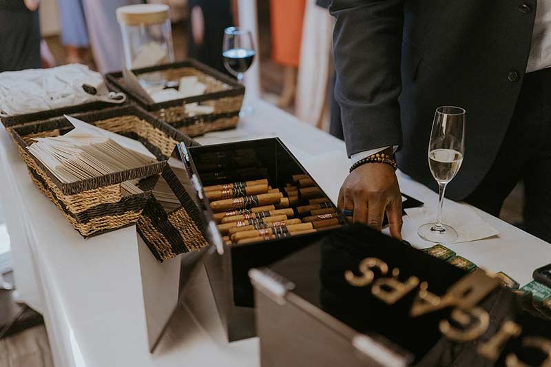 Cigar bar display with wooden box, champagne flutes and wedding favors at reception