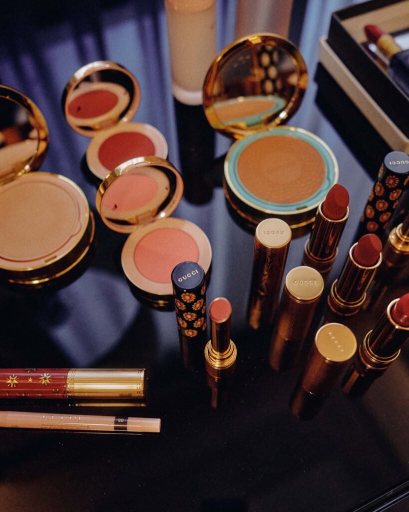 Gucci beauty products including blush compacts lipsticks and bronzer on vanity table