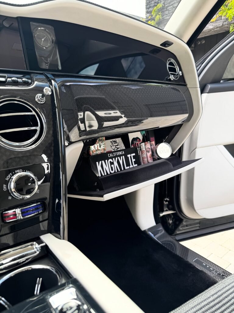 Interior of Kylie Jenner's custom Rolls-Royce showing KNGKYLIE license plate and Kylie Cosmetics lip kits