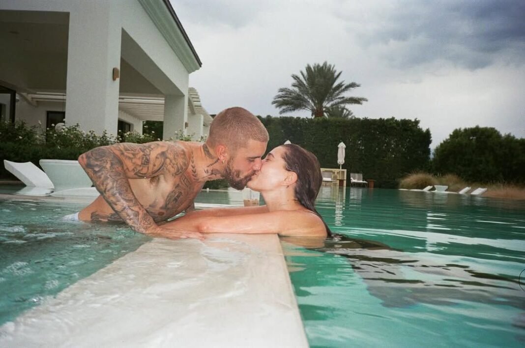 Justin and Hailey Bieber share romantic kiss in luxury pool at private estate with palm trees and modern architecture