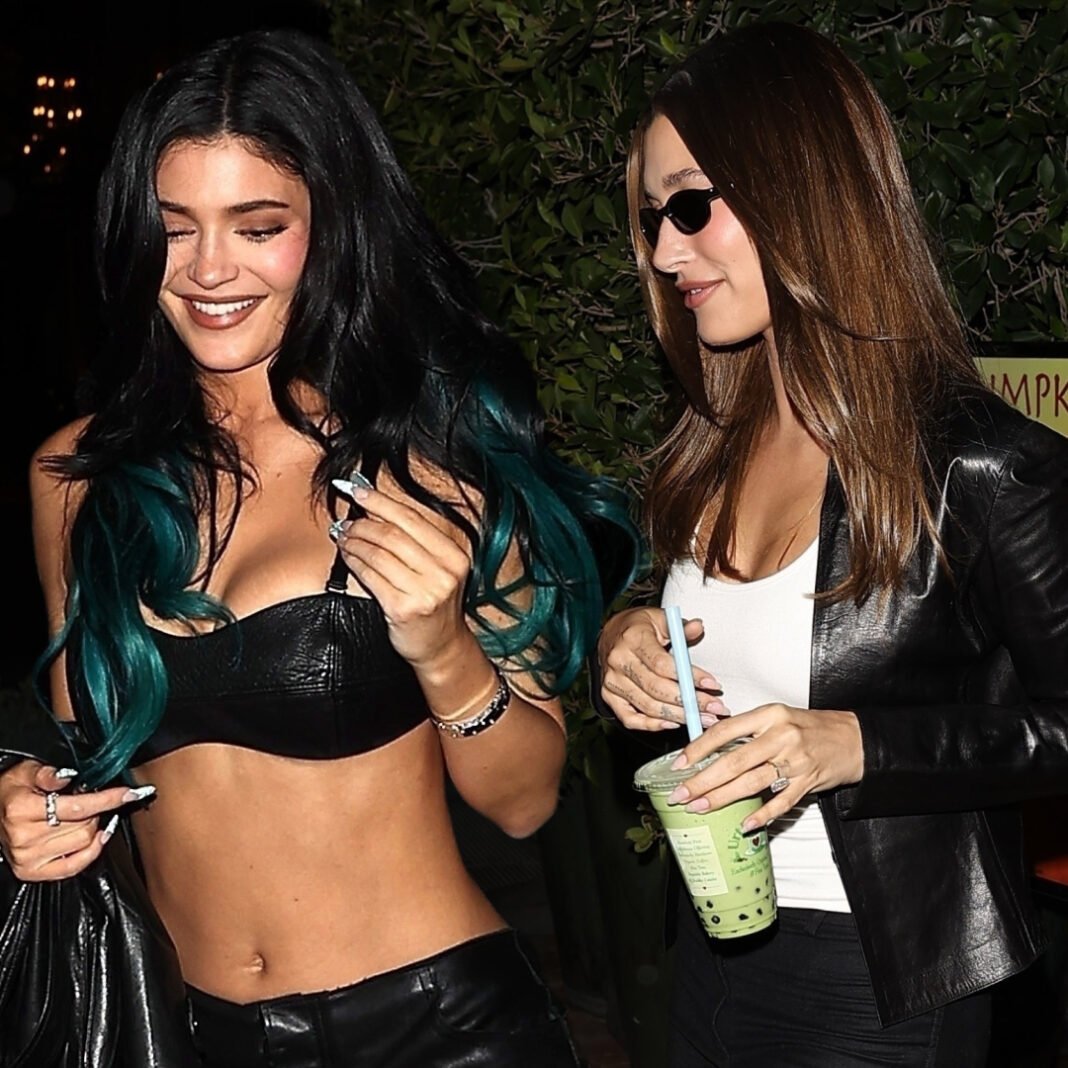 Kylie Jenner and Hailey Bieber sharing candid moment with matching green tea boba drinks at night