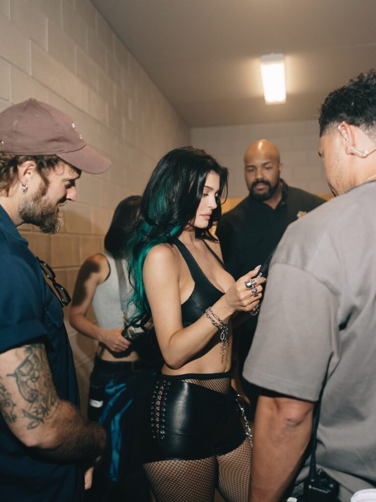 Kylie Jenner with teal-tipped hair on set surrounded by production team during music video shoot