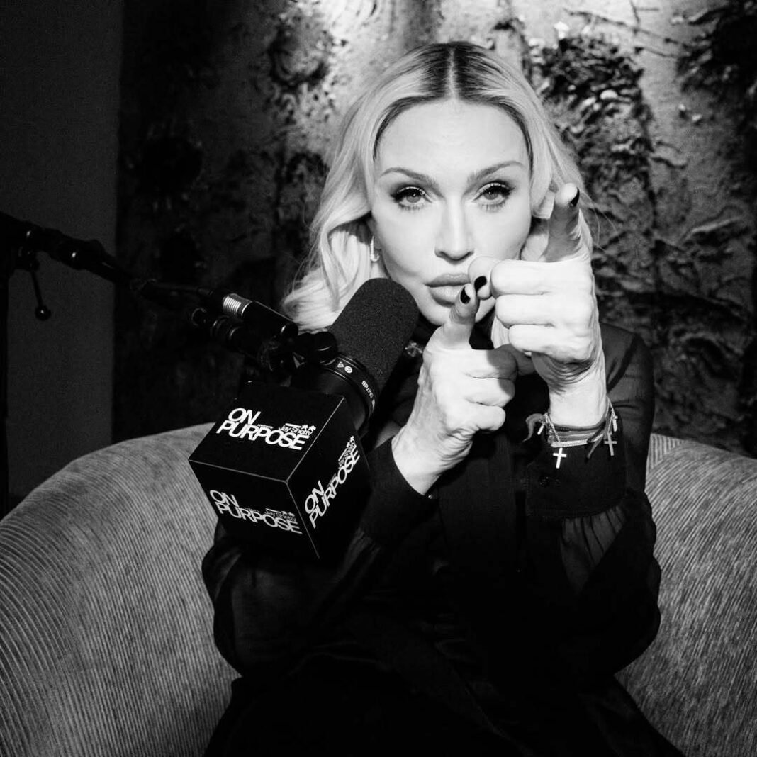 Madonna in contemplative pose with On Purpose podcast microphone during intimate black and white interview with Jay Shetty