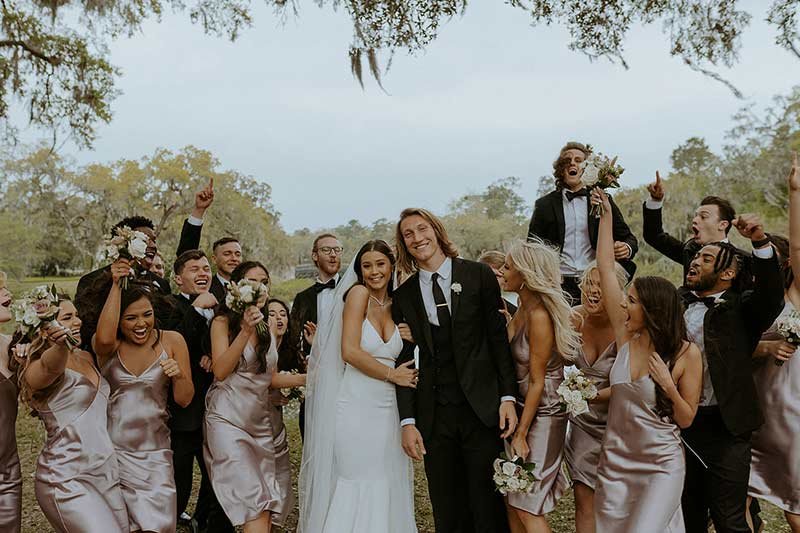 Trevor and Marissa Lawrence celebrating with full wedding party, bridesmaids in champagne dresses and groomsmen in tuxedos