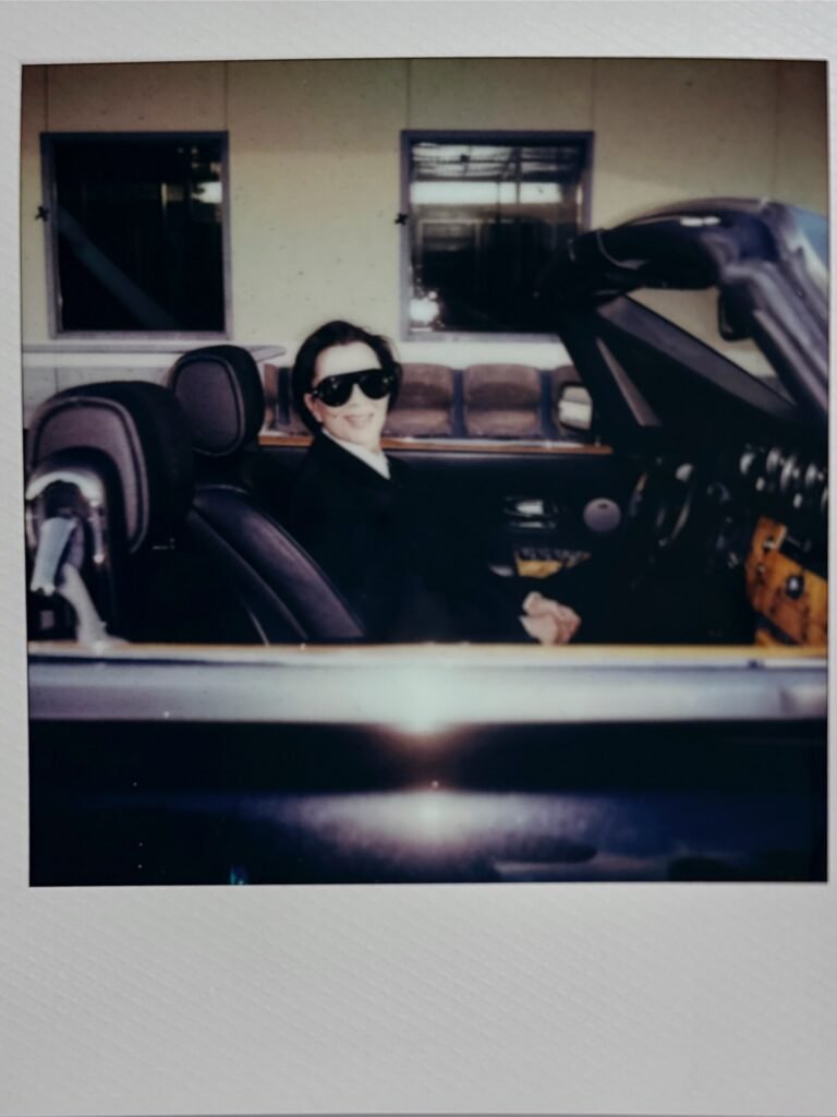 Vintage Polaroid of Kylie Jenner in convertible car wearing sunglasses