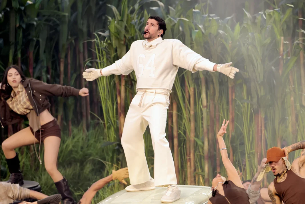 Bad Bunny performs at Super Bowl halftime show standing atop white vintage car surrounded by dancers and live string orchestra with towering sugarcane backdrop