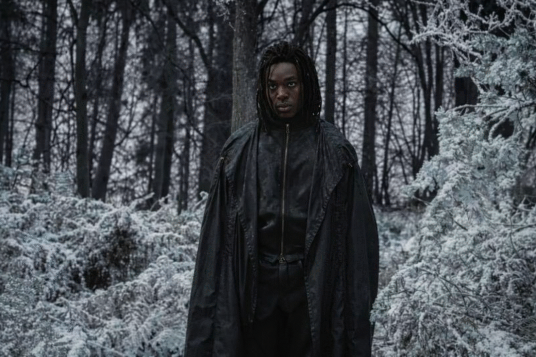 Paapa Essiedu as Professor Severus Snape in HBO's Harry Potter and the Philosopher's Stone (2026), standing in a dark hooded cloak among snow-covered trees in the Forbidden Forest