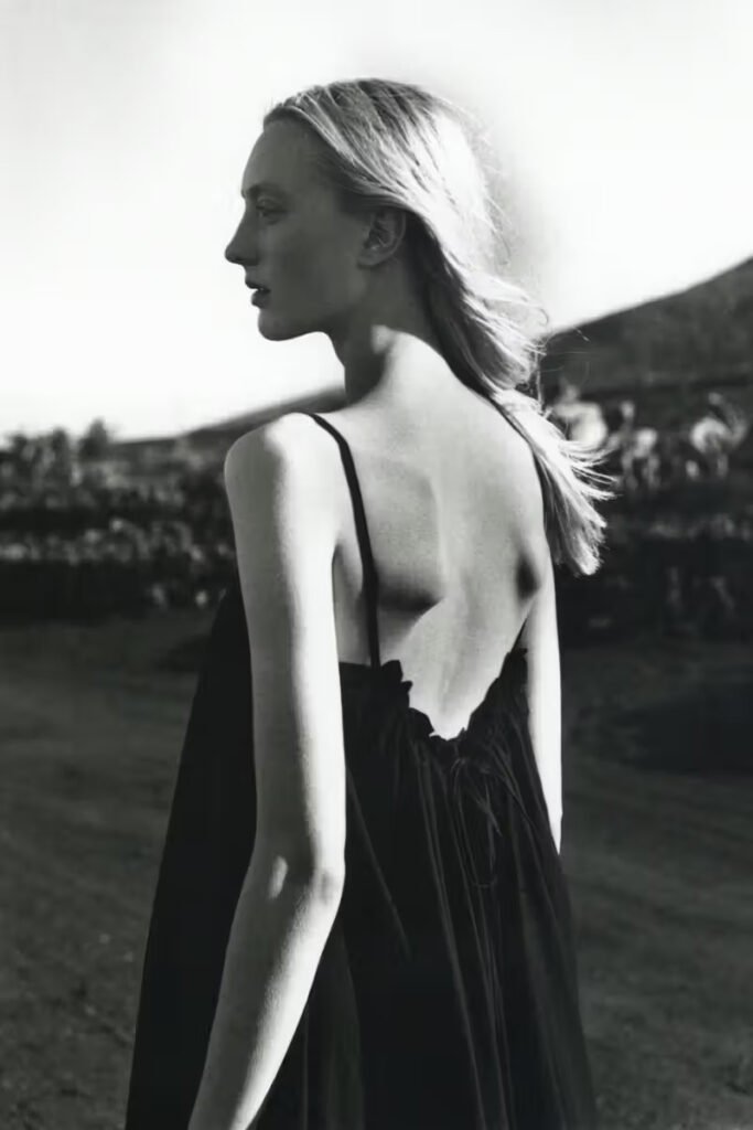 Studio-Nicholson-SS26-female-model-in-a-low-back-slip-dress-photographed-in-black-and-white-on-location
