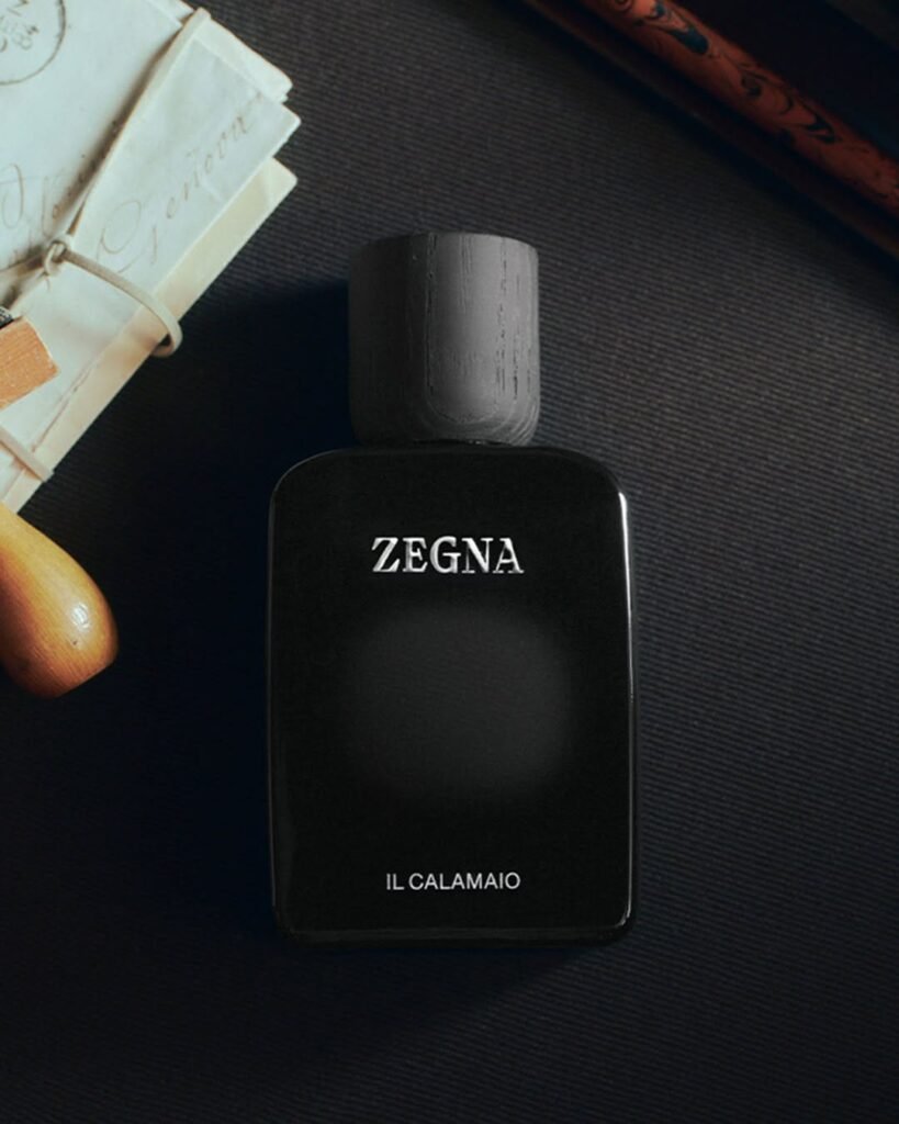 ZEGNA-MEMORIE-Il-Calamaio-fragrance-bottle-in-black-with-wooden-cap-styled-alongside-vintage-letters-and-a-wax-seal-stamp-on-a-dark-textured-surface