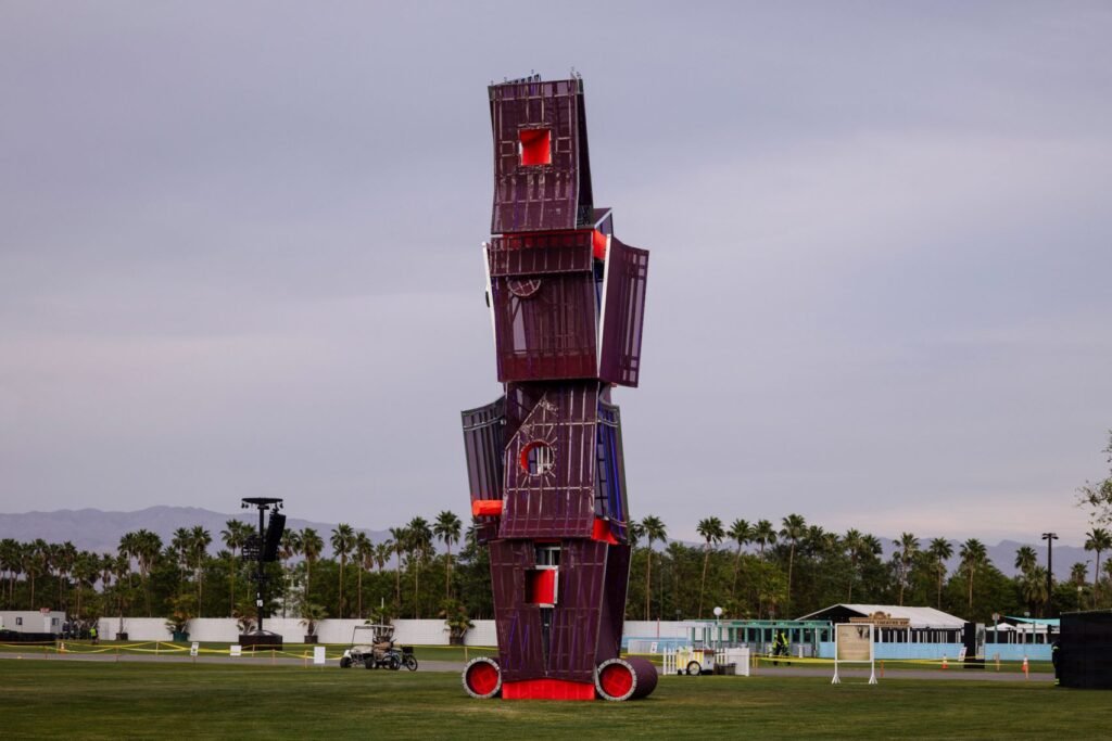 LADG's 'Visage Brut' at Coachella 2026, a towering stack of warped deep-purple steel boxes with red accents rising above the Empire Polo Club grounds at dusk.