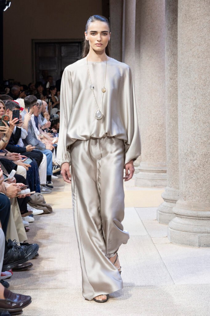 A-model-walks-the-Giorgio-Armani-Cruise-2027-runway-in-a-fluid-neutral-satin-blouse-and-matching-wide-leg-trousers