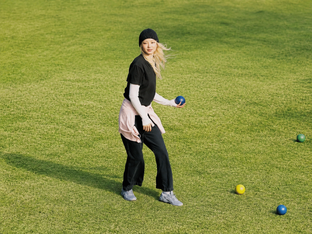 ASICS-Sensory-Bloom-Collection-editorial-illustration-of-a-woman-in-grey-lifestyle-sneakers-playing-lawn-bowls-on-a-green