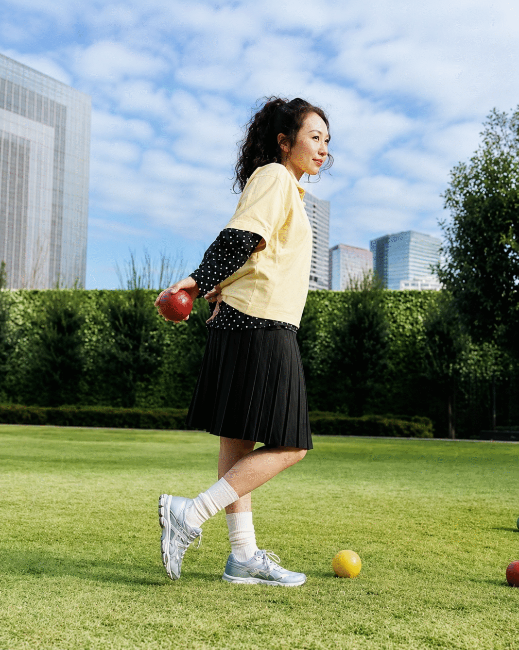 Anna-Sawai-wears-the-ASICS-GEL-CUMULUS-16-with-a-pleated-skirt-and-yellow-top-on-a-lawn-in-the-Sensory-Bloom-campaign