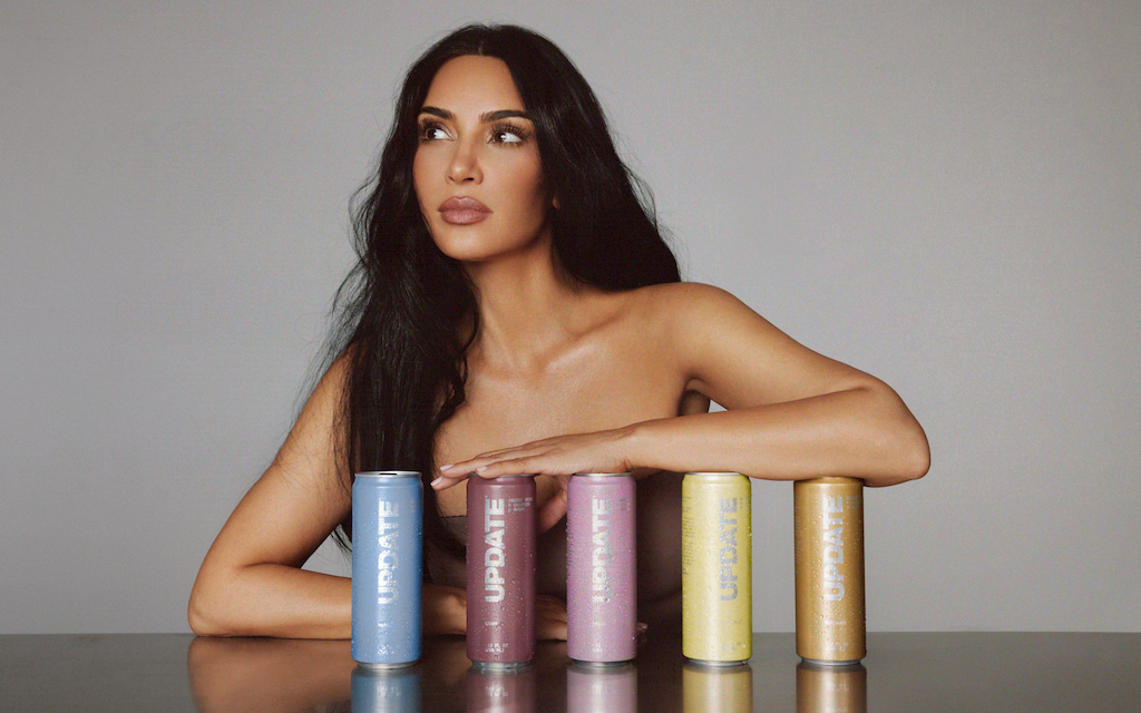 Kim Kardashian poses behind five colorful UPDATE energy drink cans