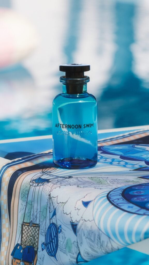 Louis-Vuitton-Afternoon-Swim-perfume-bottle-on-a-printed-silk-scarf-at-the-edge-of-a-pool