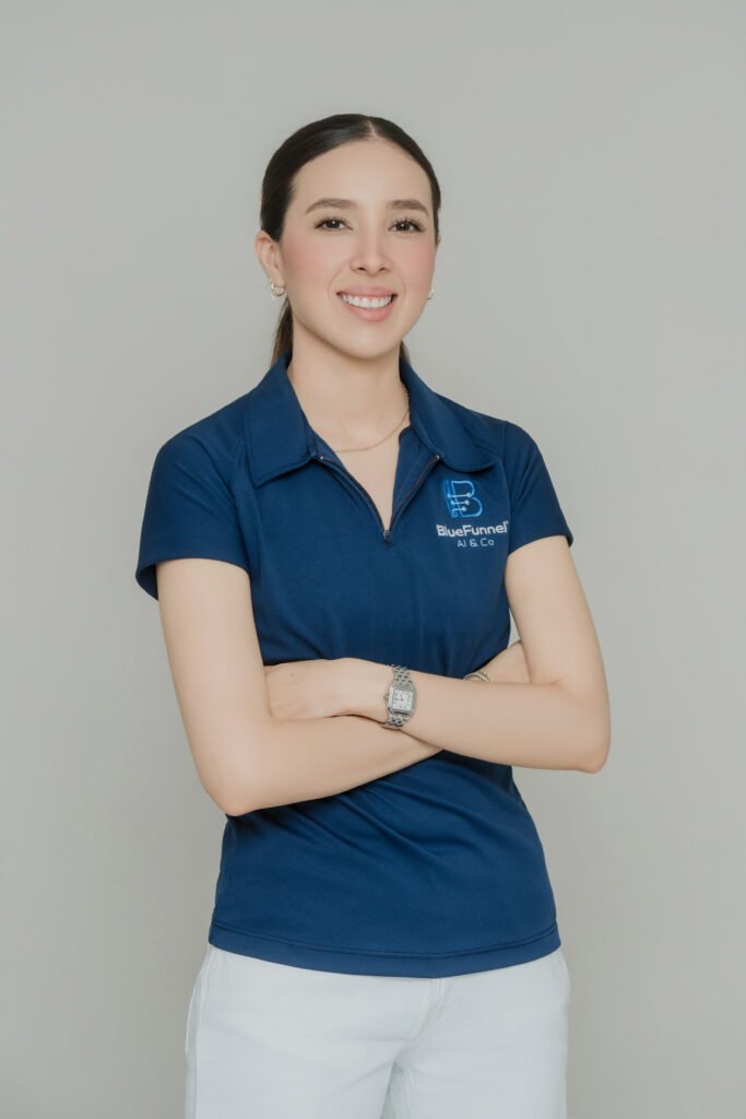 Mariana Maldonado, CMO and CTO of BlueFunnel AI & Co, smiling with arms crossed, wearing a navy BlueFunnel AI & Co branded polo shirt