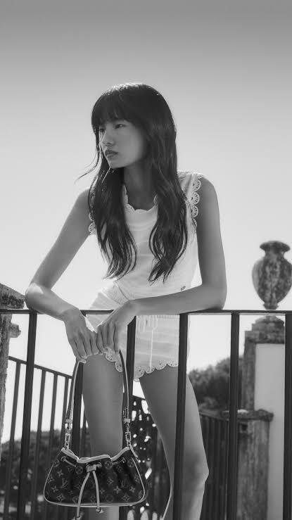 Model-in-a-Louis-Vuitton-scalloped-white-top-and-shorts-with-a-Monogram-bag-in-black-and-white