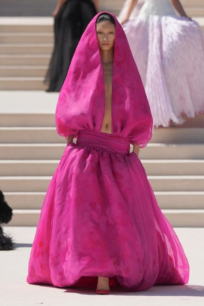 Model-in-a-fuchsia-silk-organza-hooded-gown-with-billowing-sleeves-and-a-full-skirt-on-the-Balenciaga-55th-couture-runway-in-Paris
