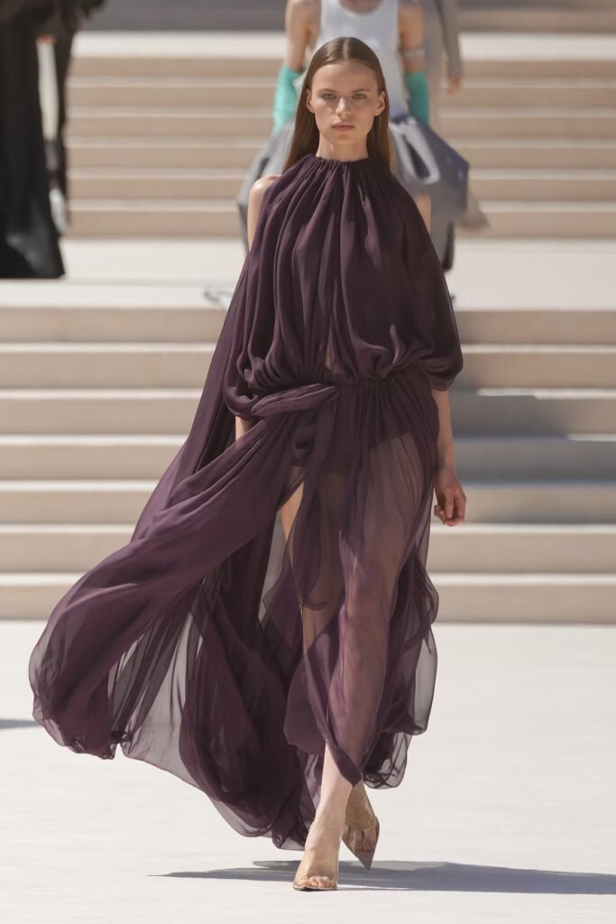 Model-in-a-sheer-plum-silk-chiffon-gathered-gown-with-draped-sleeves-and-clear-heels-on-the-Balenciaga-55th-couture-runway-in-Paris