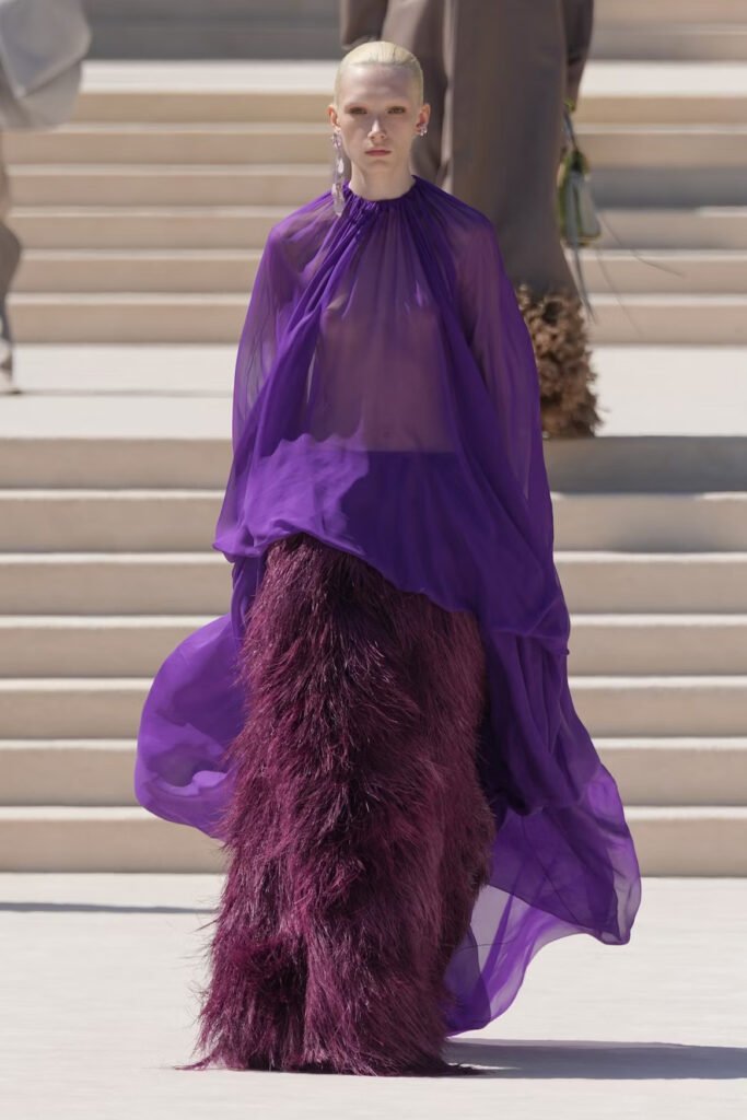 Model in a sheer purple chiffon cape top over a plum ostrich-feather skirt on the Balenciaga 55th couture runway in Paris.