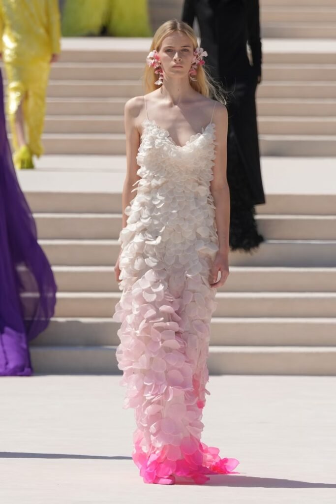 Model-in-an-ombre-petal-applique-slip-gown-fading-from-ivory-to-fuchsia-with-floral-earrings-on-the-Balenciaga-55th-couture-runway-in-Paris