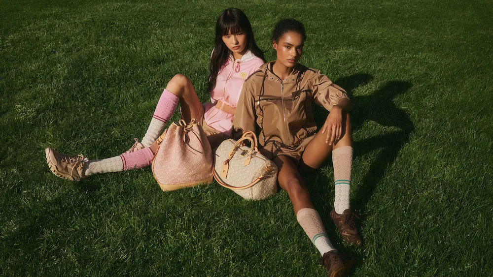 Models-in-Louis-Vuitton-pink-and-tan-zip-up-jackets-on-grass-with-pink-Monogram-Noe-and-cream-Speedy-bags