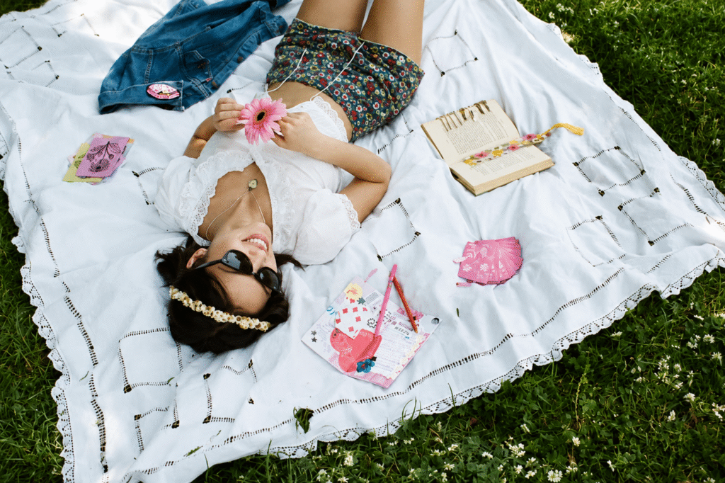Olivia-Rodrigo-surrounded-by-Daisy-Chain-Fields-Etsy-pieces-including-a-junk-journal-and-patches