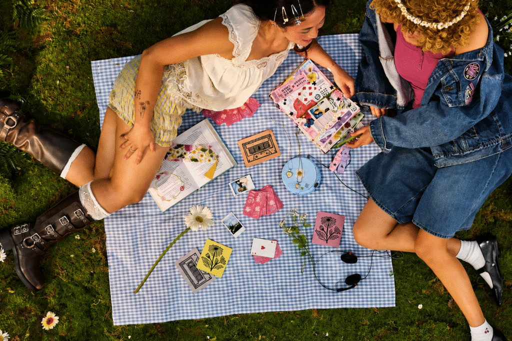 Two-festivalgoers-with-Daisy-Chain-Fields-Etsy-pieces-including-linocut-cards-and-a-junk-journal