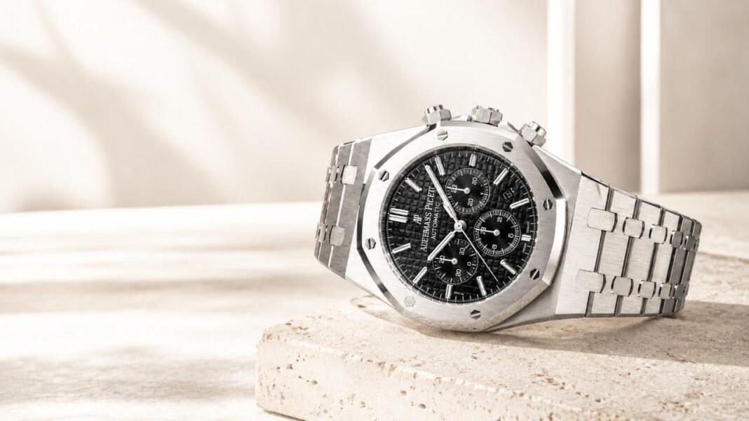 AP Royal Oak 26240 chronograph watch with a black textured dial and stainless steel integrated bracelet displayed on a stone surface