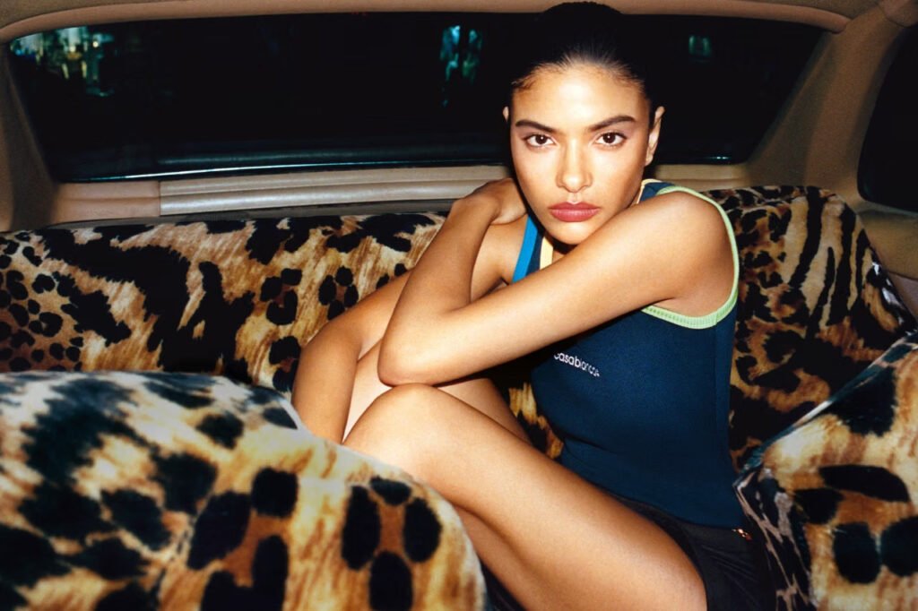 Casablanca-FW26-Carnet-de-Voyage-campaign-shot-by-Theo-Liu-a-model-in-a-navy-Casablanca-logo-tank-top-seated-on-leopard-print-car-upholstery-in-Cairo-at-night