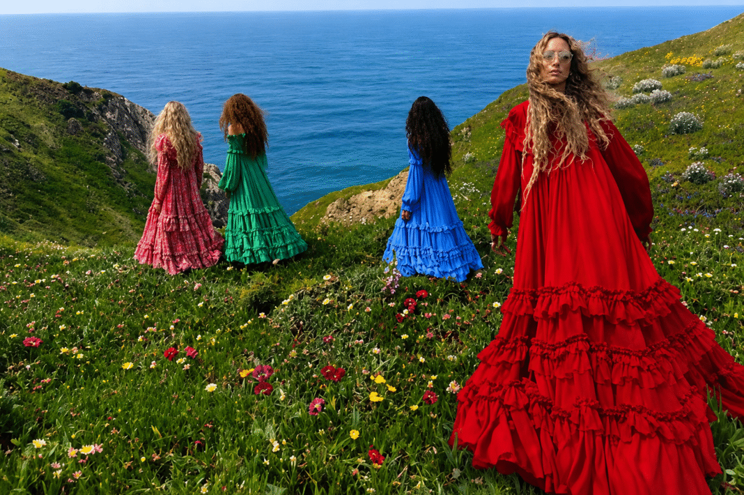 Chloé Windswept Winter 2026 campaign four women in flowing tiered maxi dresses on a coastal wildflower hillside.