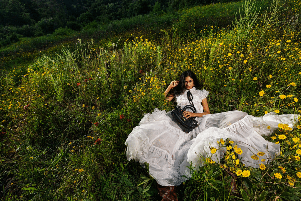 Chloe-campaign-model-in-a-white-ruffled-tulle-gown-reclines-in-a-wildflower-meadow