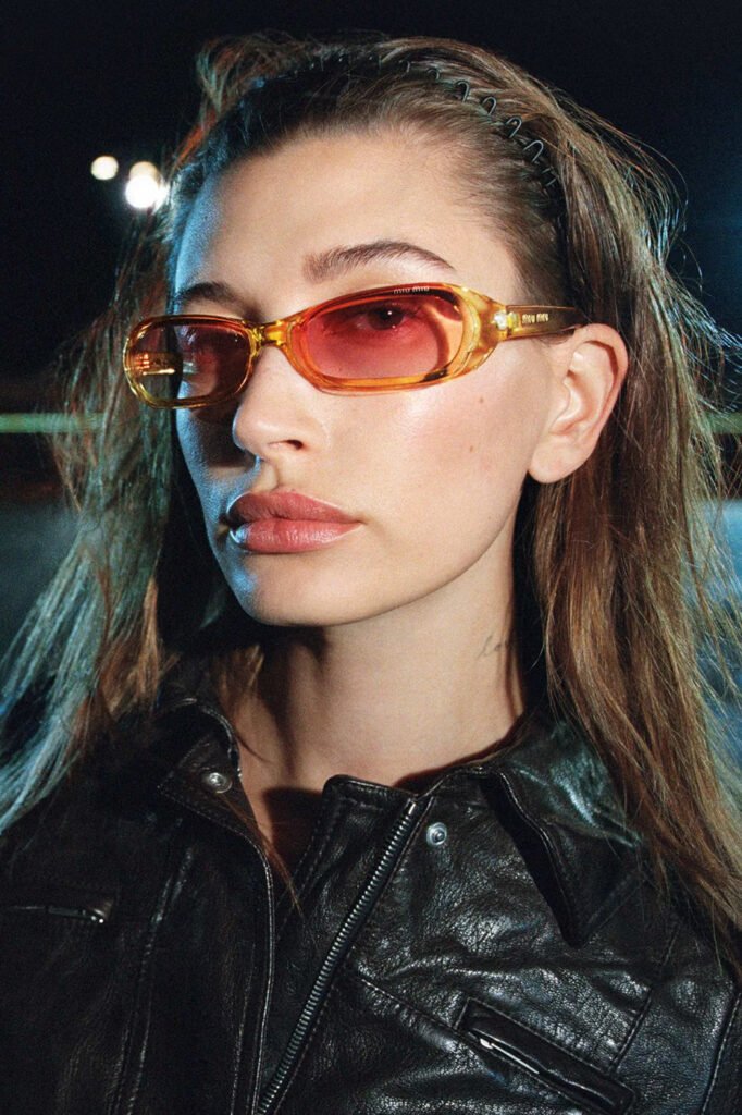 Hailey-Bieber-in-amber-tinted-Miu-Miu-sunglasses-and-a-black-leather-jacket-shot-at-night-for-the-Miu-Miu-FallWinter-2026-campaign