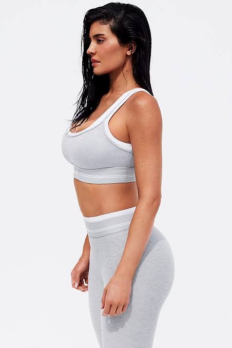 Kylie Jenner in a gray Alo bra and matching leggings, side profile
