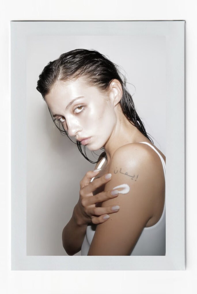Model-applying-Misaj-Glow-Protect-cream-to-her-shoulder-with-an-Arabic-script-tattoo