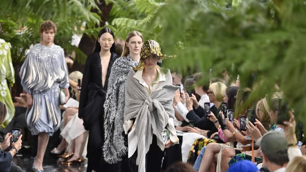 Models walk the runway in sculptural Dior designs during an outdoor fashion show