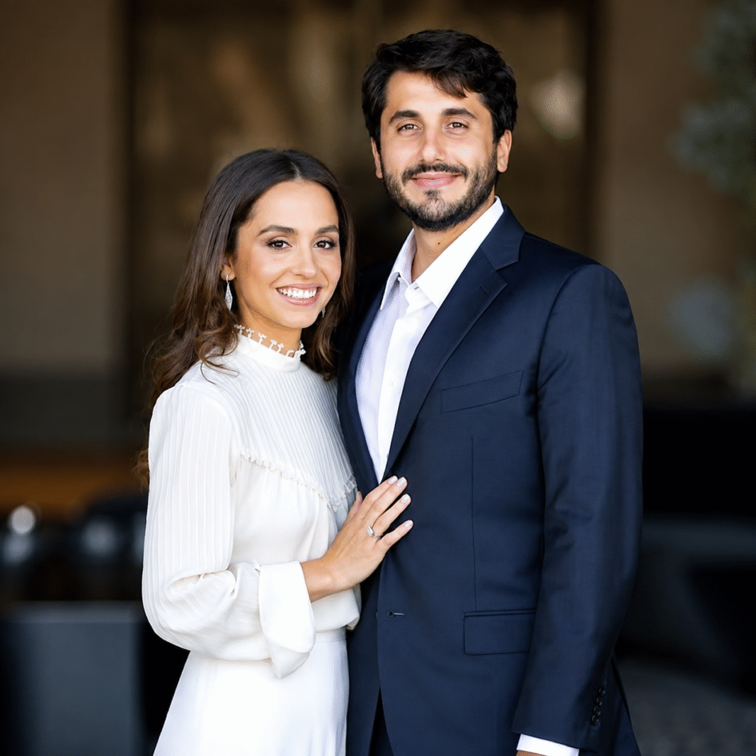 Princess Iman of Jordan in a white high-neck blouse beside husband Jameel Thermiotis in a navy suit for a formal portrait