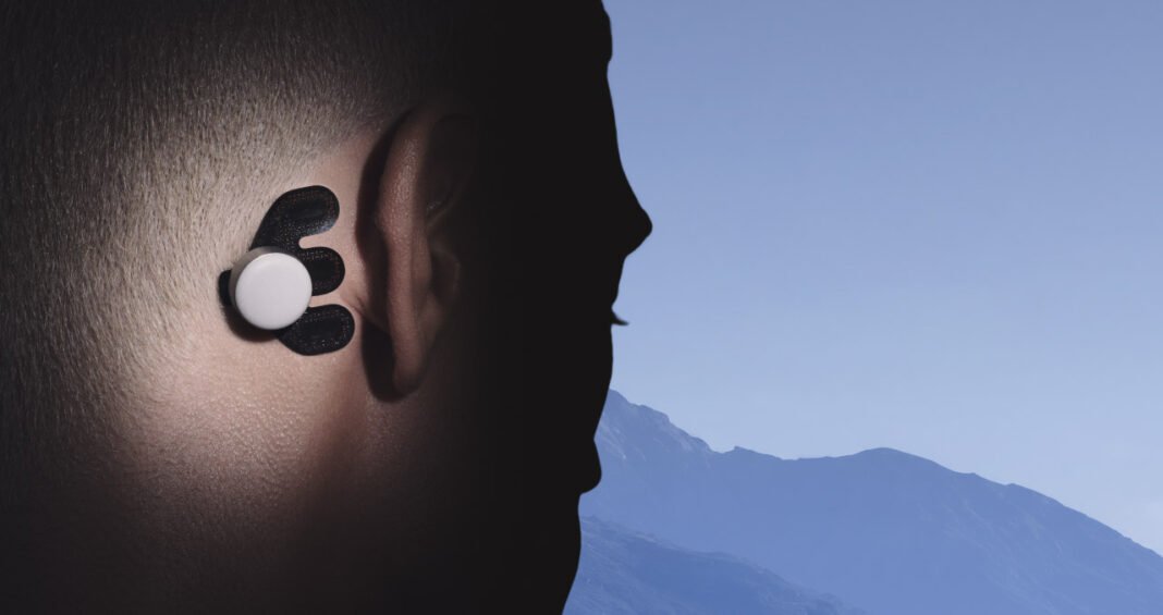 Atlas wearable worn behind a person's ear.