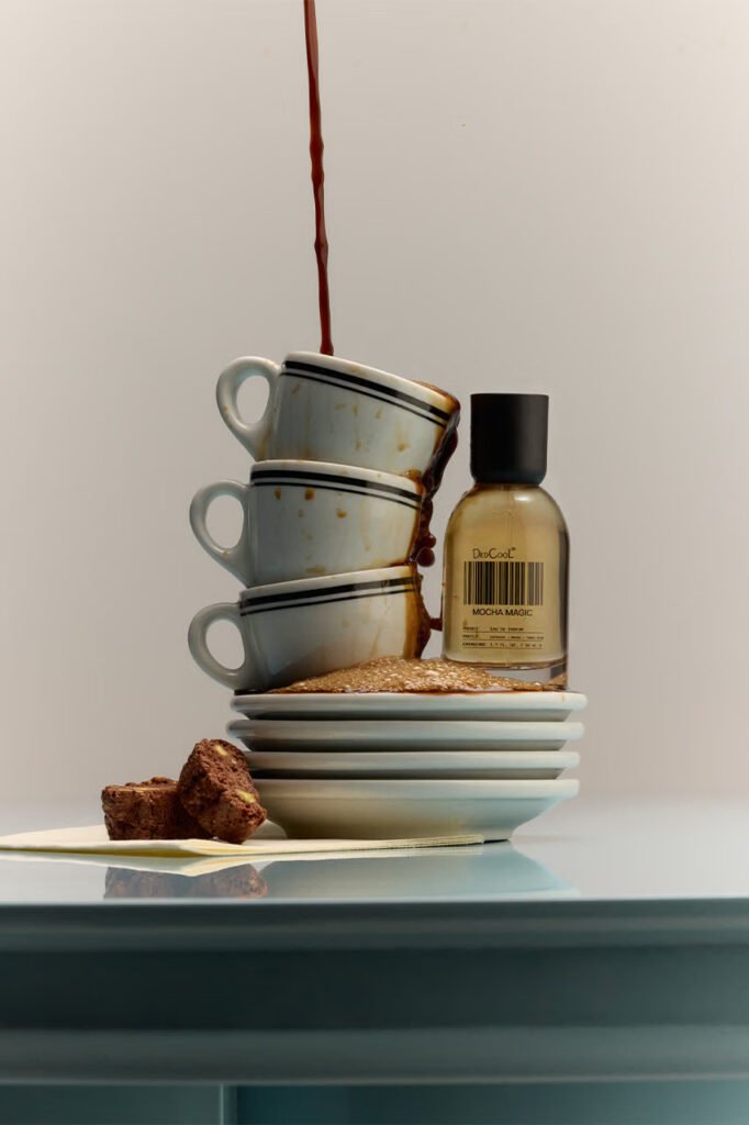 DedCool-Mocha-Magic-bottle-beside-stacked-espresso-cups-overflowing-with-coffee-and-biscotti-pieces