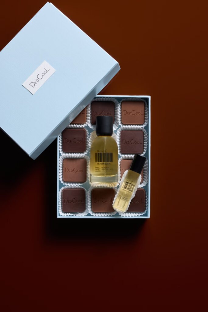 DedCool-Mocha-Magic-full-size-and-travel-bottles-set-in-a-blue-chocolate-box-of-DedCool-branded-truffles