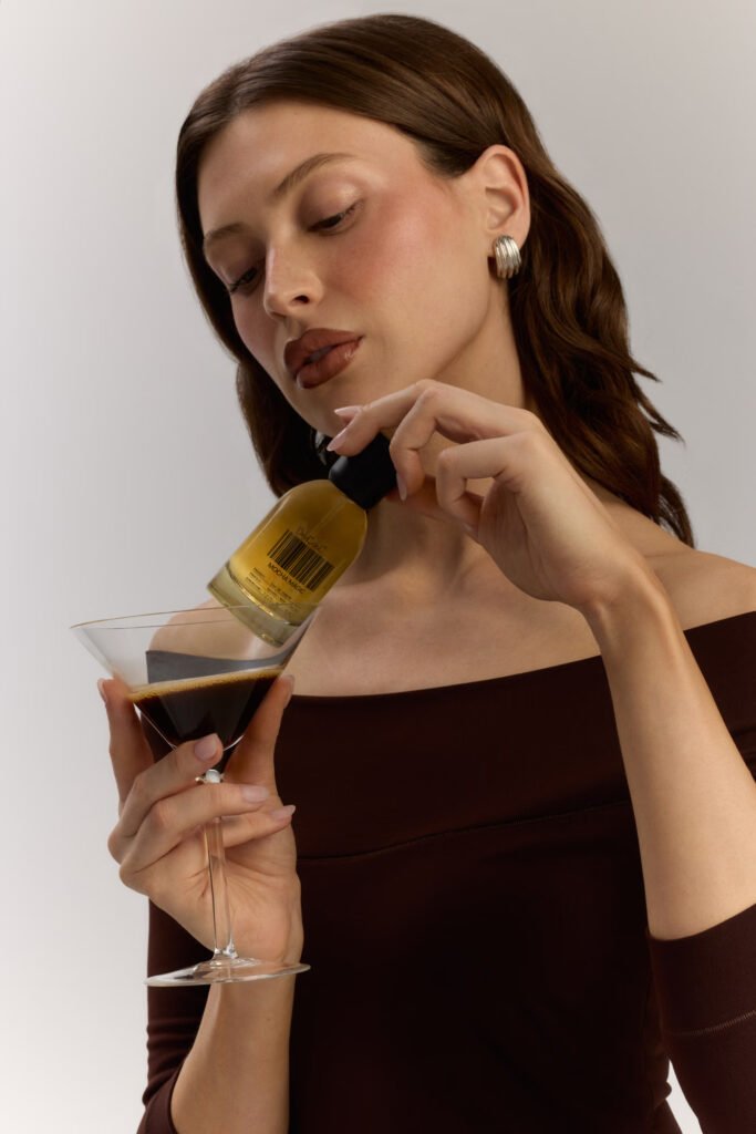 Model-in-a-brown-off-shoulder-top-holding-an-espresso-martini-and-a-DedCool-Mocha-Magic-Eau-de-Parfum-bottle