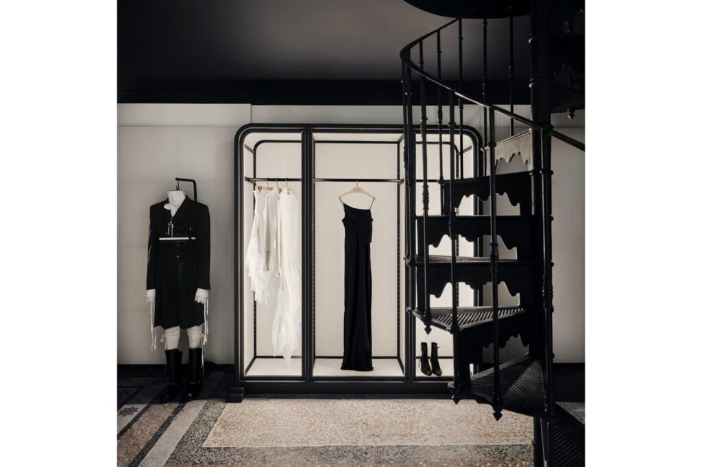 Ann-Demeulemeester-Paris-flagship-with-a-black-spiral-staircase-a-lit-wardrobe-display-of-a-black-slip-dress-and-a-mannequin