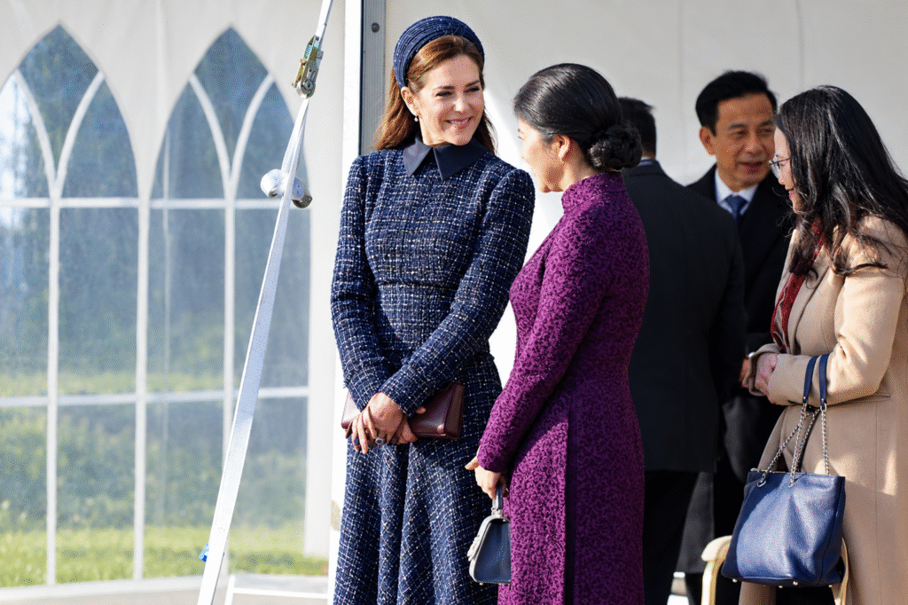 Queen-Mary-of-Denmark-in-a-navy-tweed-dress-and-headband-speaks-with-Vietnams-First-Lady-Ngo-Phuong-Ly-in-a-purple-ao-dai